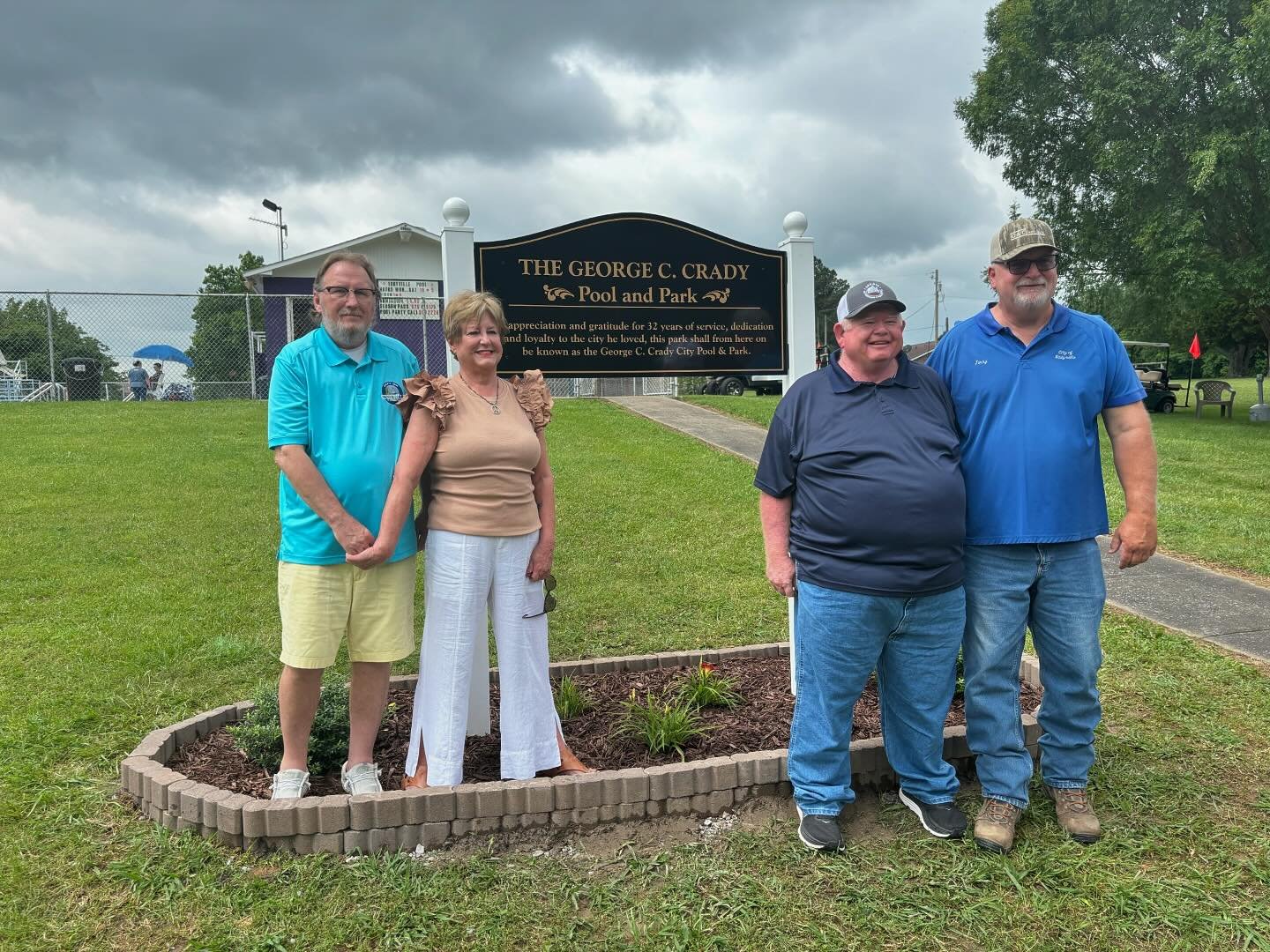 Photo of people standing next to a sign