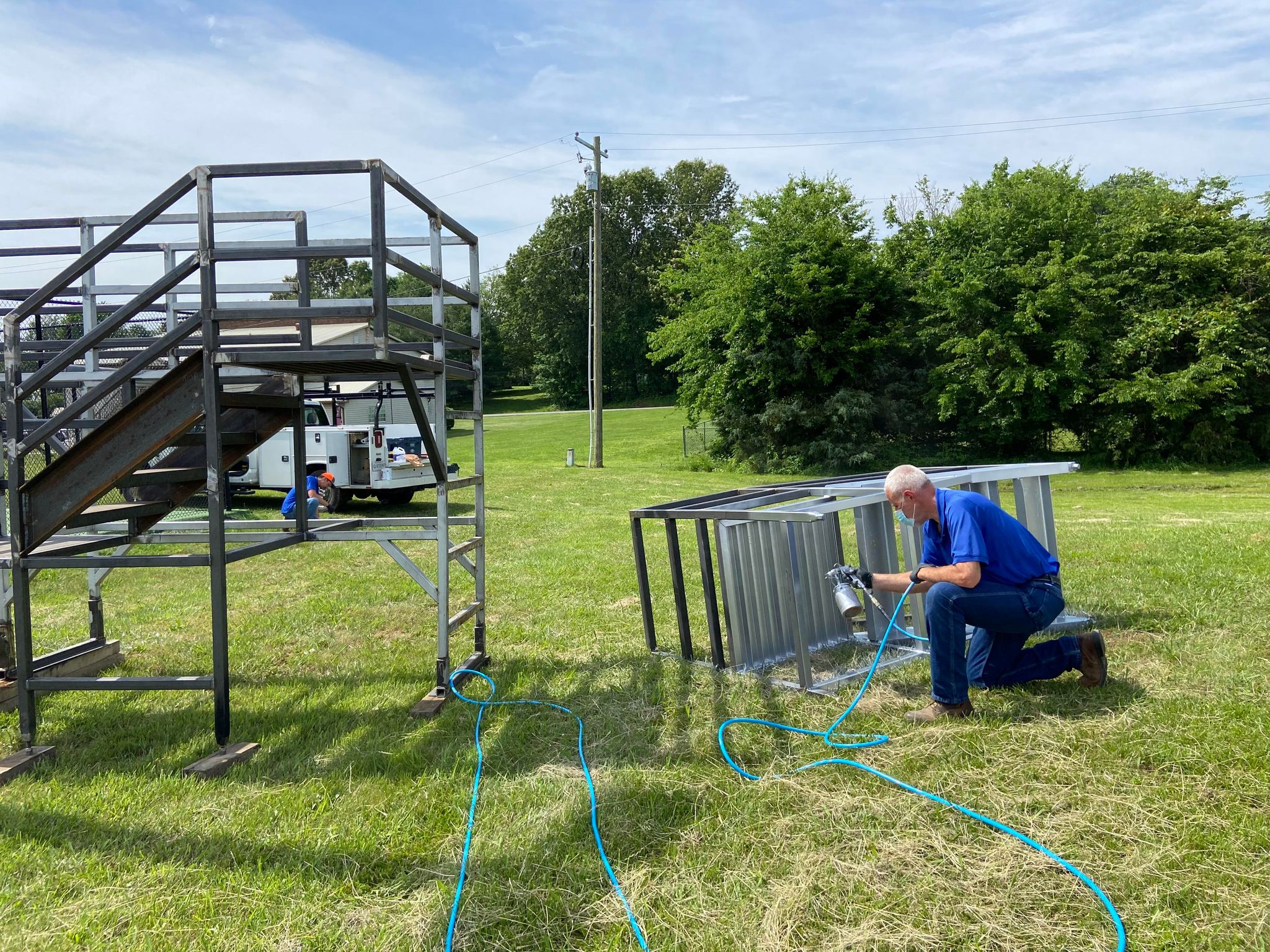 Photo of a worker painting/cleaning some bleachers/steps